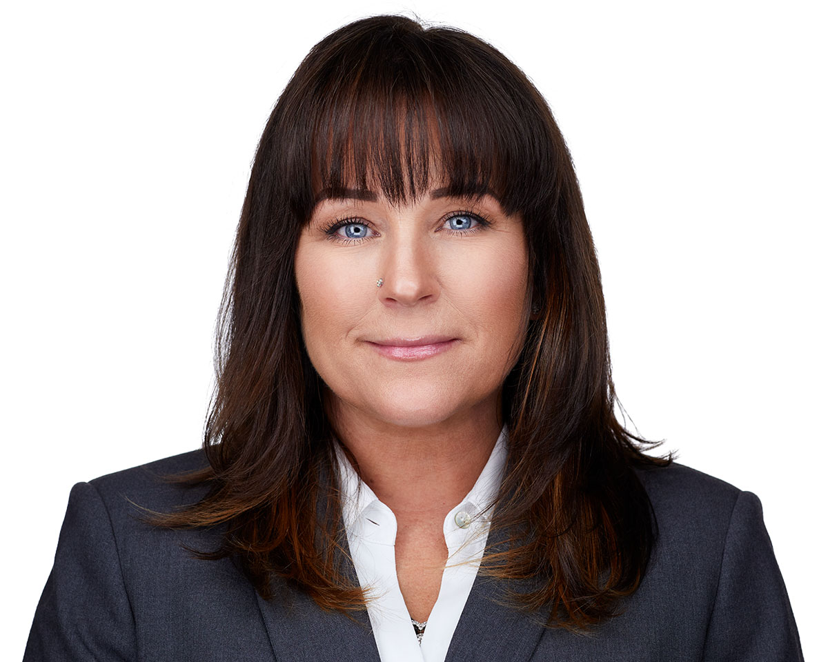 Professional female executive headshot in Los Angeles wearing a dark gray suite and smiling