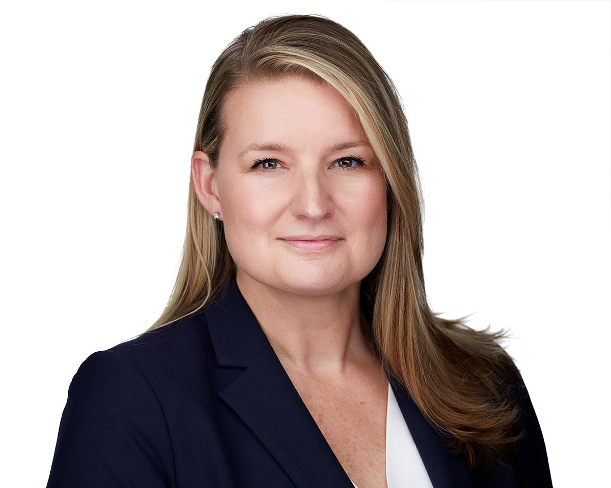 Professional white female executive headshot in Los Angeles wearing a navy jacket suite with a white blouse and smiling